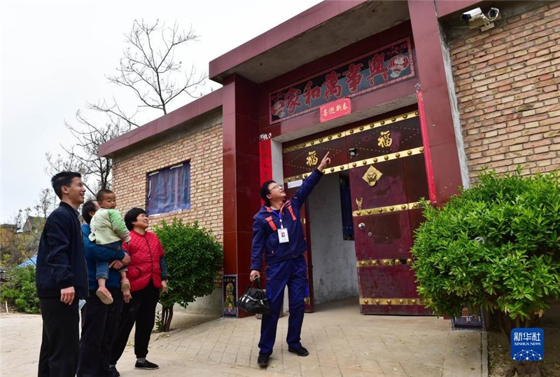 在山西省运城市平陆县郭原村，宽带维护工作人员刘青格（右一）向脱贫户董成荣一家介绍智能家居摄像头的功能（2021年4月9日摄）。新华社记者 柴婷 摄