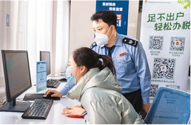 在内蒙古自治区呼和浩特市玉泉区政务服务中心自助办理区，税务人员辅导市民使用自助服务电脑办理税务业务。丁根厚摄（人民图片）