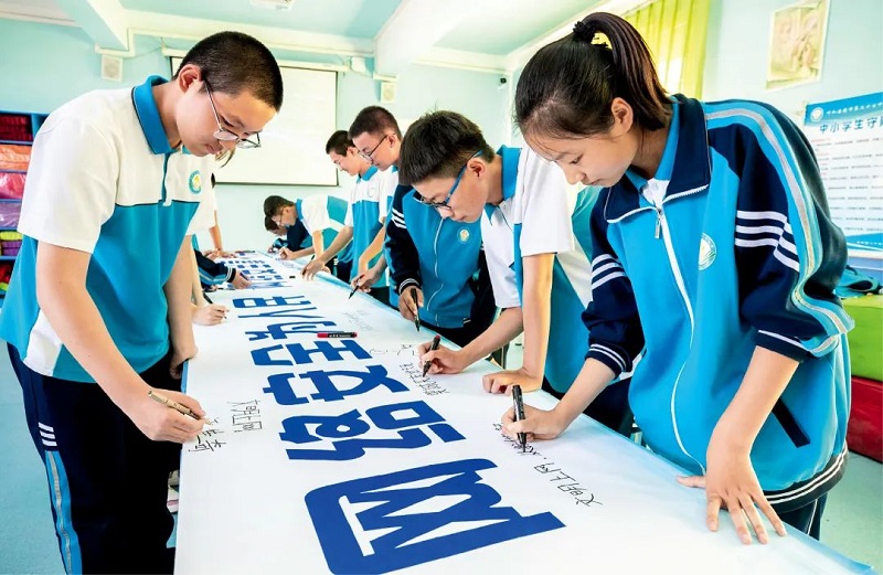 2022年9月5日，呼和浩特市第二十七中学学生在“网络安全为人民，网络安全靠人民”宣传条幅上签名。