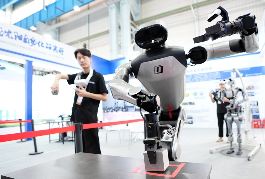 9月5日,在辽宁省沈阳市的2025全球工业互联网大会的展览区现场,中国科学院沈阳自动化研究所的机器人工程师在调试具身智能操作系统。新华社记者 李钢 摄